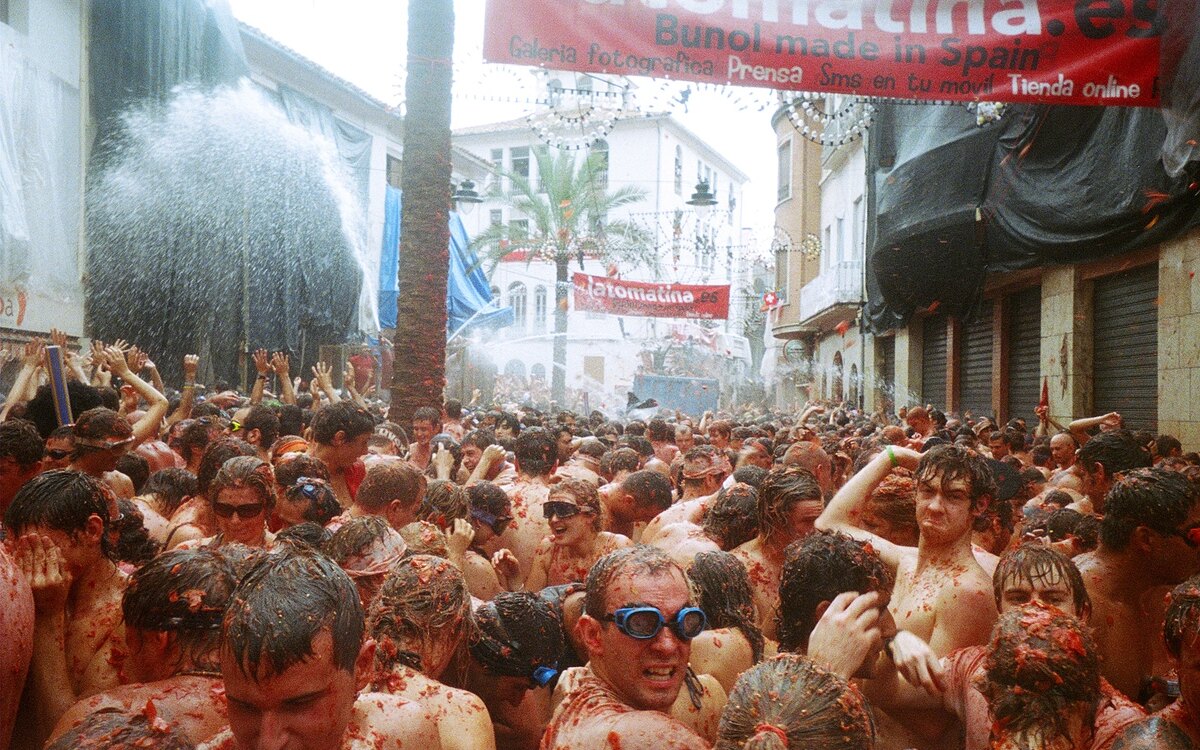 Crowds throwing tomatoes in the streets of Buñol during La Tomatina